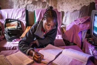 Sheila Achieng doing her studies at home in Kibera.