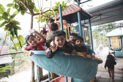 Group of children waving on a slide