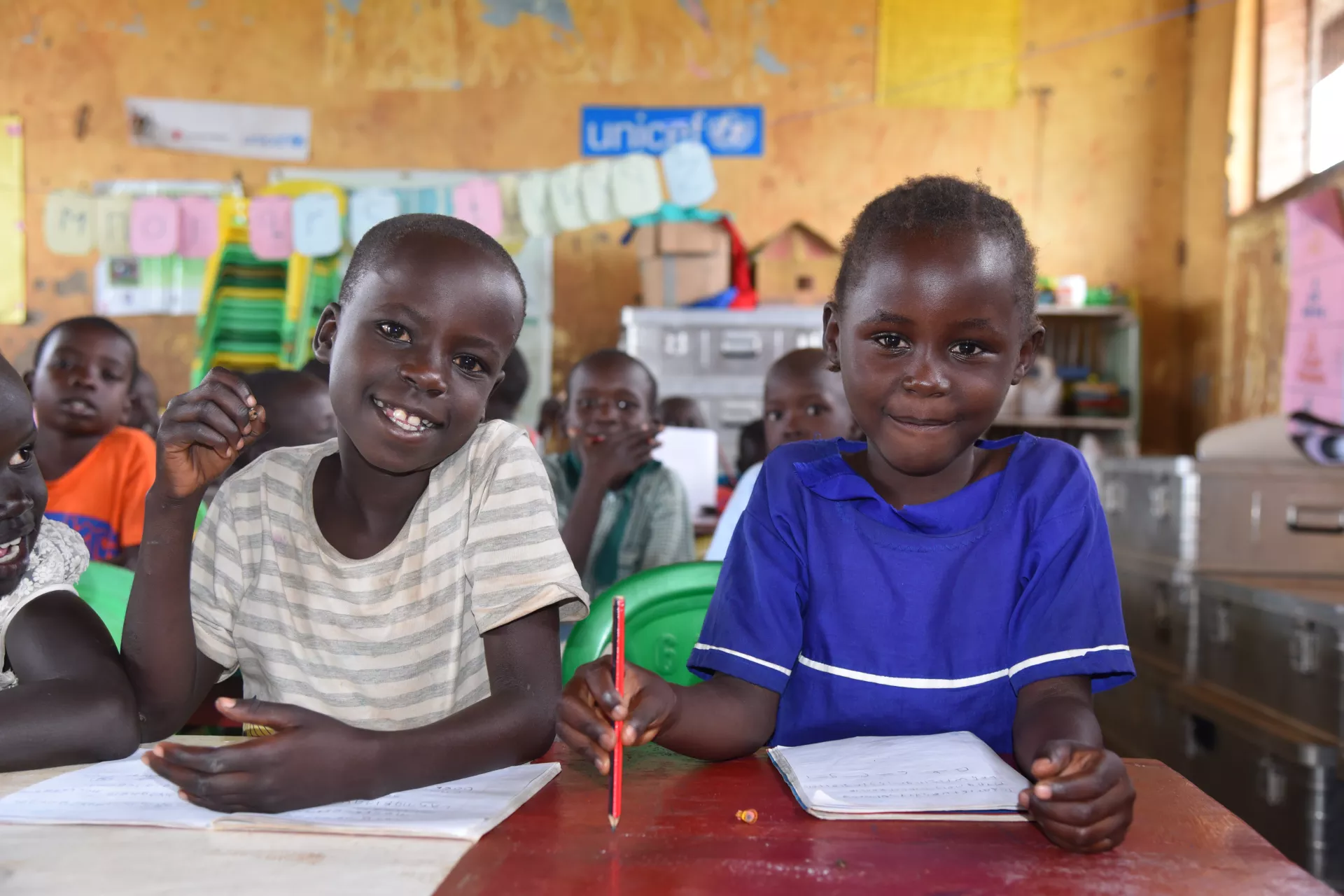 Young children have a light moment during a classroom session at a UNICEF-supported child friendly space in Adjumani District.