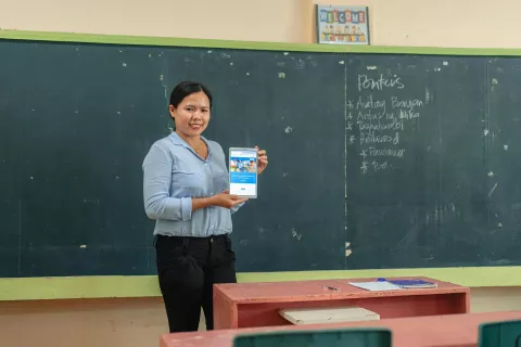 female teacher holding a tablet