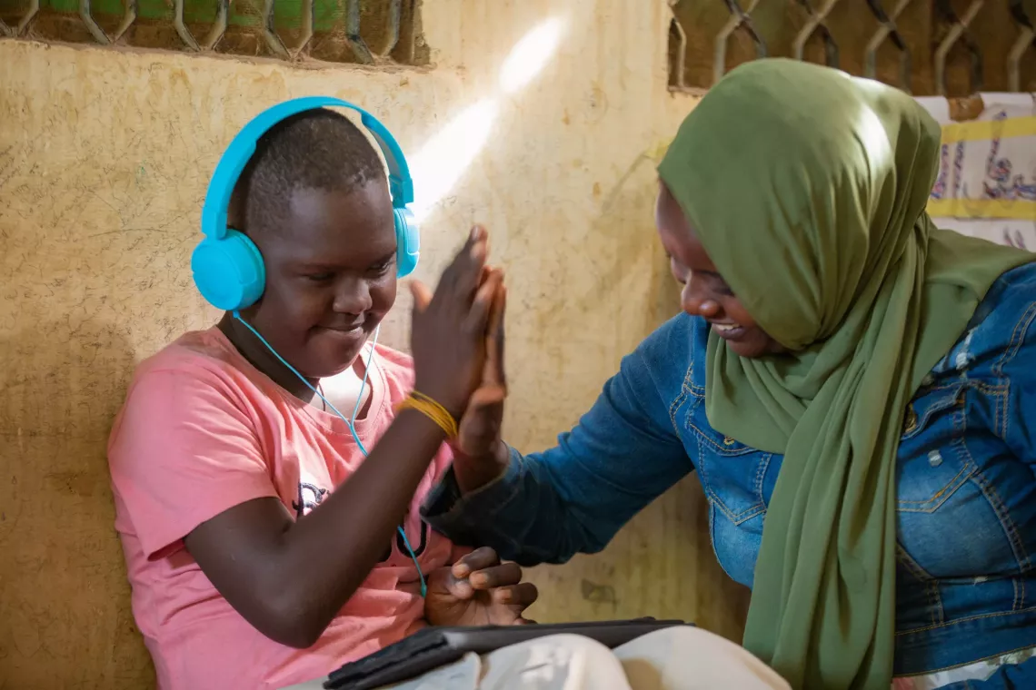 Young boy using a tablet with a headset. 