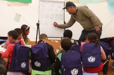 Syrian child refugees learn to count in English in a makeshift tent classroom