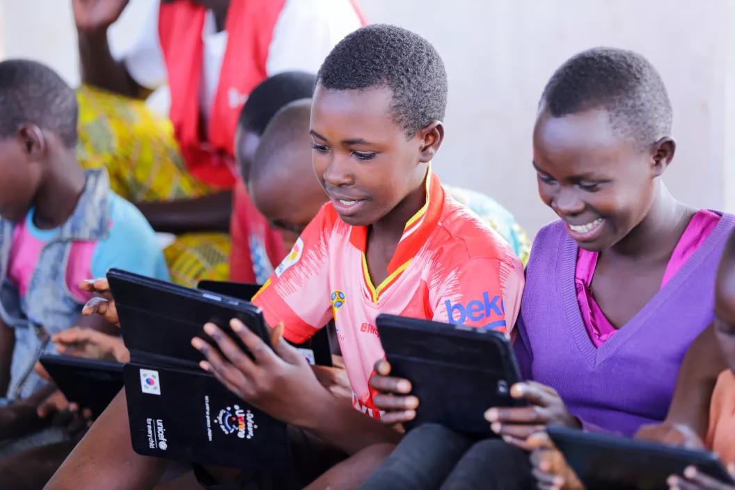 Burundian refugee children in one of Mahama Camp's child-friendly spaces play with educational apps